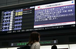 システムの不具合を伝える日航の電光掲示板=12月26日午前、羽田空港