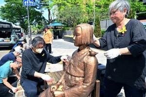 　６日、韓国・ソウルで慰安婦問題を象徴する少女像の保守作業に当たる彫刻家の金曙ギョンさん（右）ら（共同）