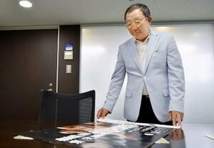 自社で印刷したポスターを見るウエマツの福田浩志社長=9月、東京都豊島区