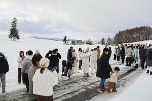 写真撮影をする人で混雑する「クリスマスツリーの木」（左奥）の周辺＝２０２５年１２月、北海道美瑛町