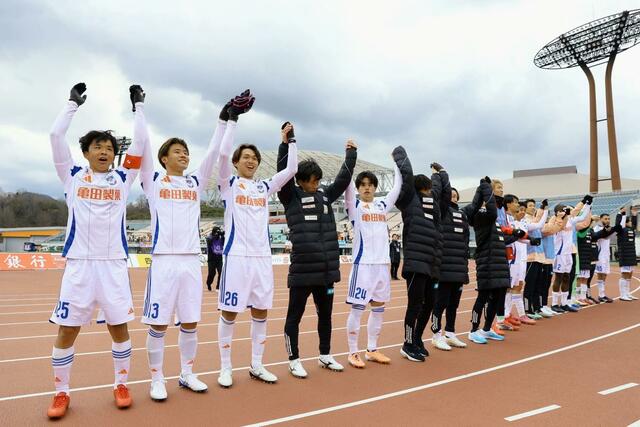 初勝利となり、サポータ－と喜びを分かち合う新潟の選手＝松山市