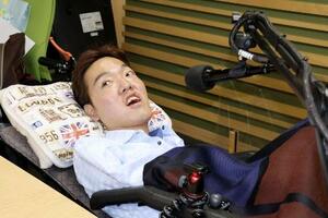 FM番組「寝たきり社長のおはようエール」の収録に臨むパーソナリティーの佐藤仙務さん=5月、名古屋市