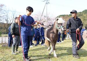 シャングシャング馬の開催を前に黒川中学校を訪問した松原正文さん(右)=14日、胎内市太田野原