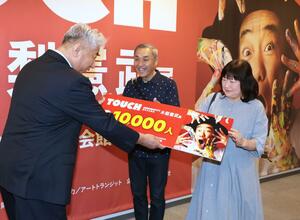 木梨憲武展の来場1万人を記念して図録などが贈られた=16日、新潟市中央区