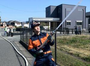 　防災訓練で放水する冨玖チュアンさん＝３月、熊本県合志市