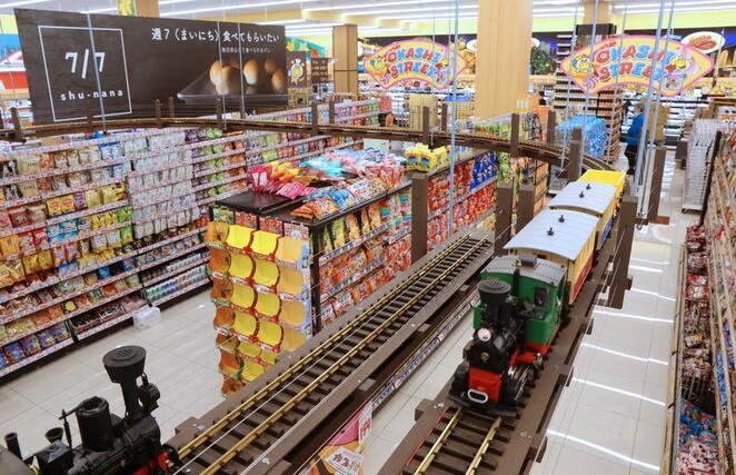 お菓子売り場の頭上には模型のSLが走るロピアムサシ新潟店=22日、新潟市中央区