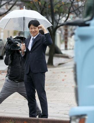 行き交う車へ挨拶する梅谷守さん＝上越市