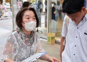 署名を呼びかける平野フミ子さん(左)=8日午後、熊本市