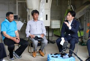 石川県輪島市の復興状況を視察し、農家らと意見交換する小泉農相(右)=25日午後