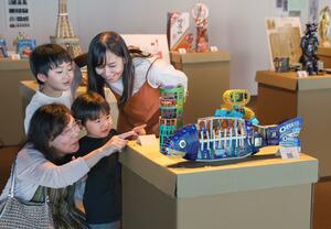 空き箱で作ったアート作品を見る家族=2日、新潟市中央区万代3