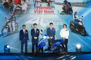生産4千万台目の記念のバイクとホンダの塚本飛佳留開発生産統括部長(左から2人目)ら=30日、ハノイ郊外(共同)