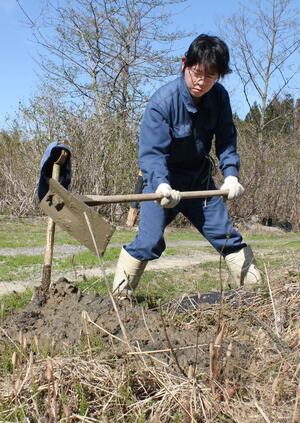 田んぼに水を引く水路にたまった泥などを清掃する古岩樹さん=上越市西鳥越