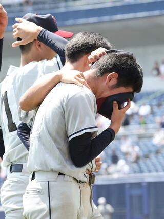 中越-関根学園 2-3で中越に敗れ、帽子で顔を覆って涙する関根学園のエース鈴木興丞(手前)=7月24日、新潟市中央区長潟のハードオフ・エコスタジアム