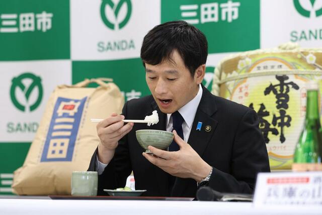 三田市産コシヒカリを試食する上越市の中川幹太市長＝２９日、兵庫県三田市川除のＪＡ兵庫六甲三田支店
