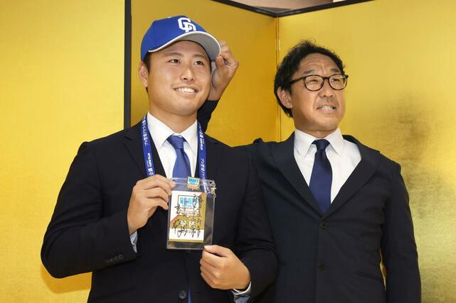 中日と仮契約し、八木智哉スカウト（右）と記念撮影をする牧野憲伸＝新潟市中央区