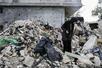 イスラエル軍の攻撃で破壊された自宅のがれきの中で持ち物を捜すアヤさん=2026年4月20日、レバノン南部ナバティエ(共同)