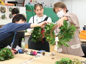 さまざまな葉を束ねてリースを作る参加者＝柏崎市軽井川