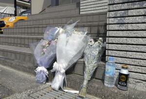 殺害された新庄博志の自宅前に手向けられた花束=2024年6月、大津市