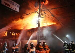 炎が上がり、消防が消火活動に当たる火災現場＝１０月１９日午後１０時３０分前、上越市本町２