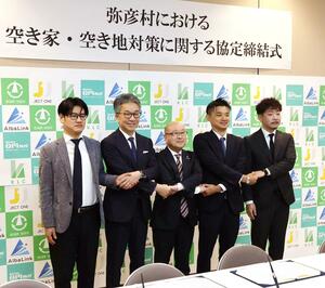 空き家・空き地活用で弥彦村と協定を結んだ関係者ら=弥彦村役場