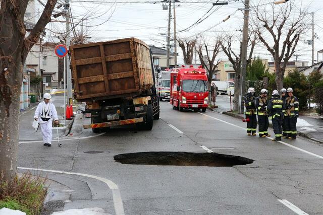 陥没した道路と、はまった車両＝９日、新潟市東区太平４