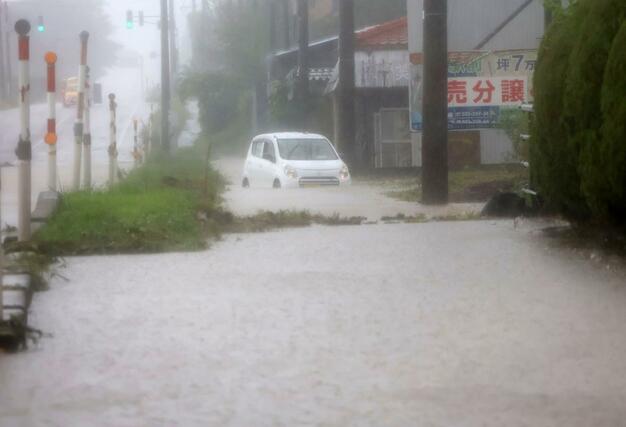 冠水した道路から抜け出せなくなった車=8日午前10時30分ごろ、新発田市下小中山