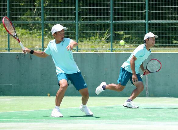 東京学館-開志国際 テニス男子団体決勝でプレーする伊藤唯(左)と主将の大内大雅=南魚沼市の大原運動公園