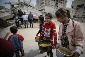 15日、パレスチナ自治区ガザ北部ガザ市で、食料の配給を受け取る避難民ら(ゲッティ=共同)