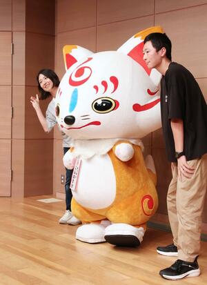 「おっきいこんのすけ」との撮影を楽しむファンたち=11日、長岡市千秋3