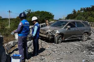 20日、カンボジア北西部でタイ軍の戦闘機による空爆を受けた橋を調べる政府職員ら(ゲッティ=共同)