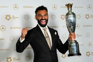 　イングランド・サッカーのプロ選手協会の男子最優秀選手に選出され、トロフィーを手に笑顔のモハメド・サラー＝１９日、マンチェスター（ＰＡ提供・ＡＰ＝共同）