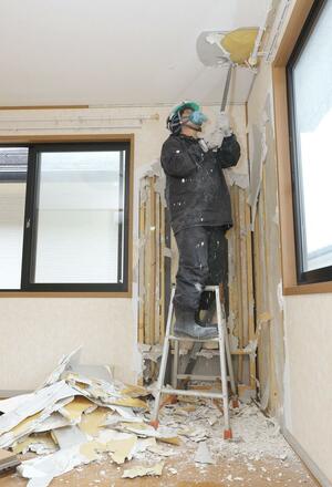 公費解体が始まった住宅。業者が壁紙をはがすなどの作業を進めている=20日、新潟市西区