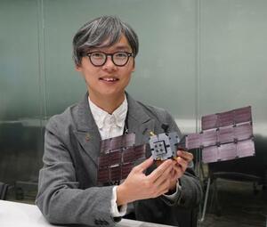 　デスティニープラスの模型を手に、小惑星探査について説明するＪＡＸＡの尾崎直哉准教授