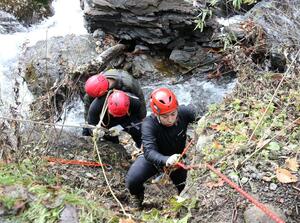 山岳救助訓練で遭難者役を引き上げる妙高署員＝妙高市