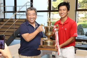 2年ぶりに優勝した橋詰海斗(右・開志国際高3年)。父とトロフィーを掲げ記念撮影する=9月11日、胎内市の中条ゴルフ倶楽部