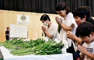 2017年の九州北部の豪雨から8年となり、営まれた追悼行事で献花し手を合わせる住民ら=6日午前、福岡県朝倉市