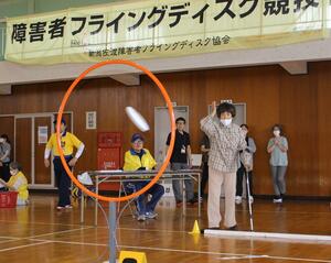 円形のゴールに向けて円盤を投げる参加者=佐渡市吉岡