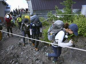10日、山開きを迎えた富士山の富士宮ルートを登る登山客=静岡県富士宮市