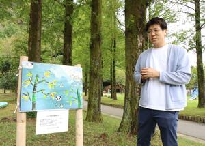 樽ケ橋遊園内に飾られた子どもたちの作品を説明する羽田健亮さん=胎内市下赤谷