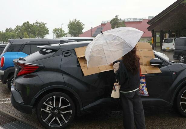 ２０台以上の車の窓ガラスが割れた新井ＰＡ。強風などによる被害とみられ、毛布などで応急措置する車もあった＝４日、妙高市猪野山

