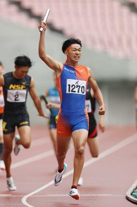 男子1600メートルリレー決勝 優勝した開志国際のアンカー・田中勇斗が右手を掲げてゴール=デンカビッグスワン