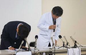 記者会見で謝罪する桑名市総合医療センターの山田典一病院長(右)ら=21日午後、三重県桑名市