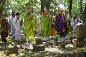 　補陀洛山寺の裏山にある「渡海上人」の墓前で読経する僧侶たち＝１７日午後、和歌山県那智勝浦町