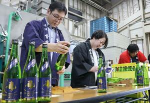 車懸のラベルを貼る酒蔵の関係者=上越市柿崎区