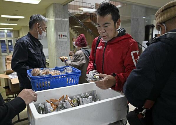 避難所で一夜を明かし、朝食を受け取る人たち＝９日午前６時半ごろ、北海道日高町