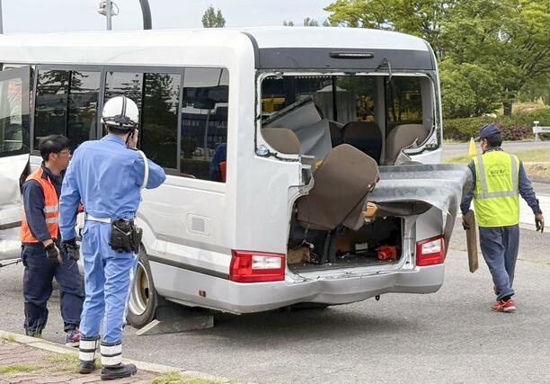 事故現場から移動されたマイクロバスを確認する警察官＝６日午後３時１１分、福島県郡山市