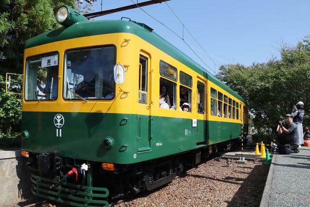 家族連れらを乗せて走る旧新潟交通電車線の「かぼちゃ電車」＝２８日、新潟市南区