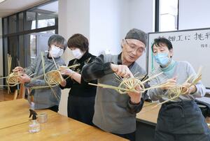 竹ひごを使って花かごを編み上げる参加者＝２２日、長岡市上の原町