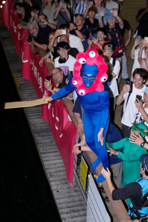 阪神タイガースが2年ぶりのセ・リーグ優勝を決め、大阪・ミナミの道頓堀川に飛び込む大阪・関西万博の公式キャラクター「ミャクミャク」に扮(ふん)した人=7日夜