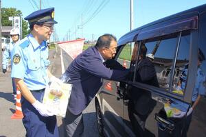 五泉の特産サトイモ「帛乙女」を配って交通安全を呼びかけた街頭指導=9月30日、五泉市本田屋